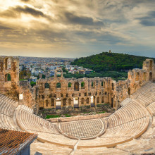 Athens amphitheatre at sunset with a view of the city in the distance