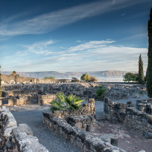 The ruin of Capernaum, the Sea of Galilee visible in the distance.
