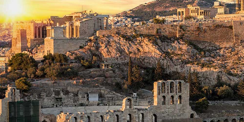 Sunset shining over the ruins of the Acropolis in Greece. Mars hill appears to be partially cut into the foundational rock.