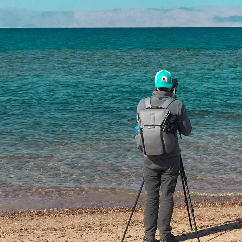 Christian man taking photographs of red sea from Saudi arabia beach thumbnail