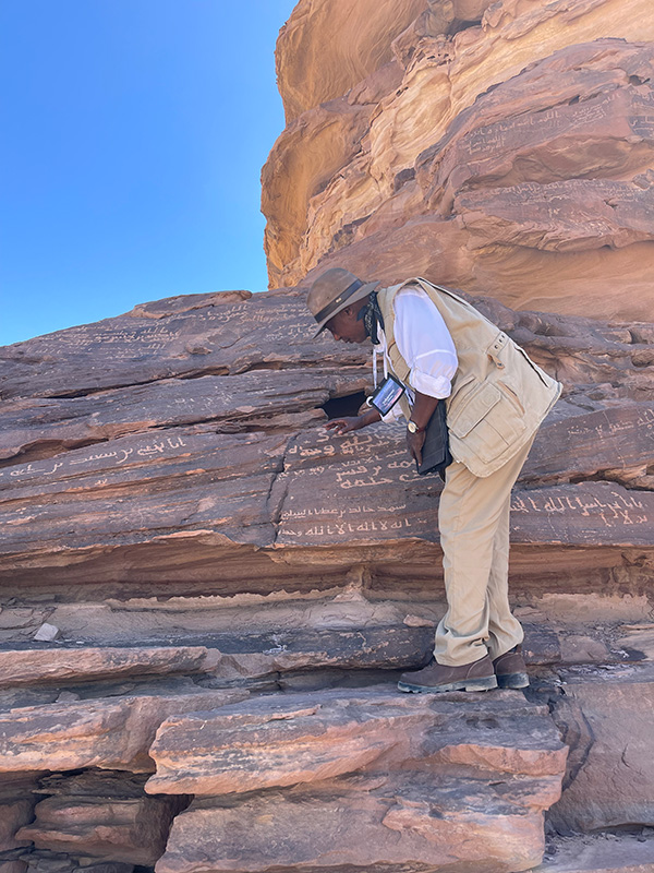 Dr. Yohannes Zeleke with ancient inscription in Saudi Arabia