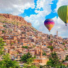 Hot air balloon flying over Mardin old town with bright blue sky Mardin, Turkey shutterstock 2450579249 Hot air balloon flying over Mardin old town with bright blue sky Mardin, Turkey shutterstock 2450579249