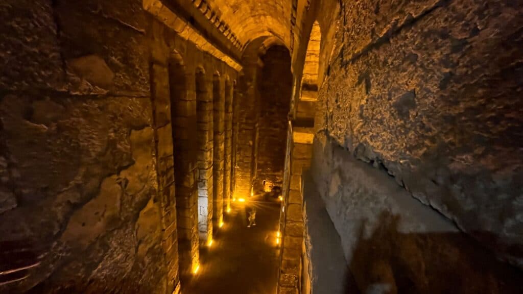 Vaulted underground cistern at the ancient city of Dara, southeastern Turkey, with stone piers and arches lit along the floor.