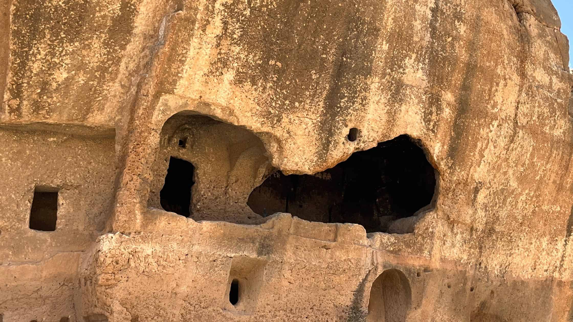 Rock-cut tomb chambers in the cliff face of the quarry-necropolis at Dara, southeastern Turkey, in late afternoon light.