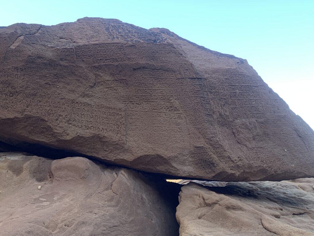 Ancient inscriptions covering a sandstone face at Jabal Ikmah,
