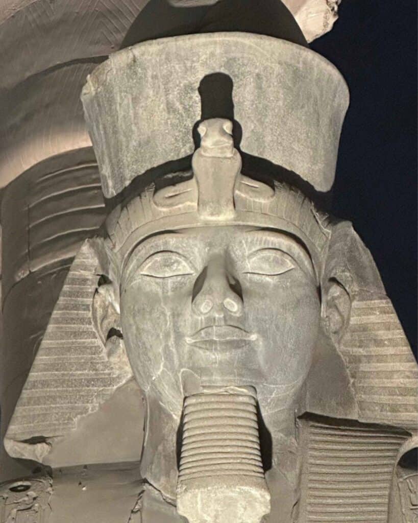 Colossal granite statue of Ramesses II at Luxor Temple showing the uraeus cobra rearing from the center of his brow